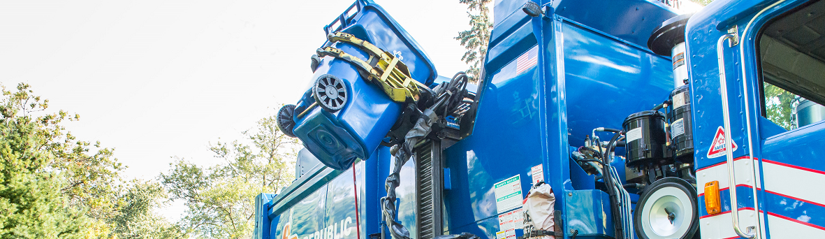 A recycling truck picking up a recycling bin.