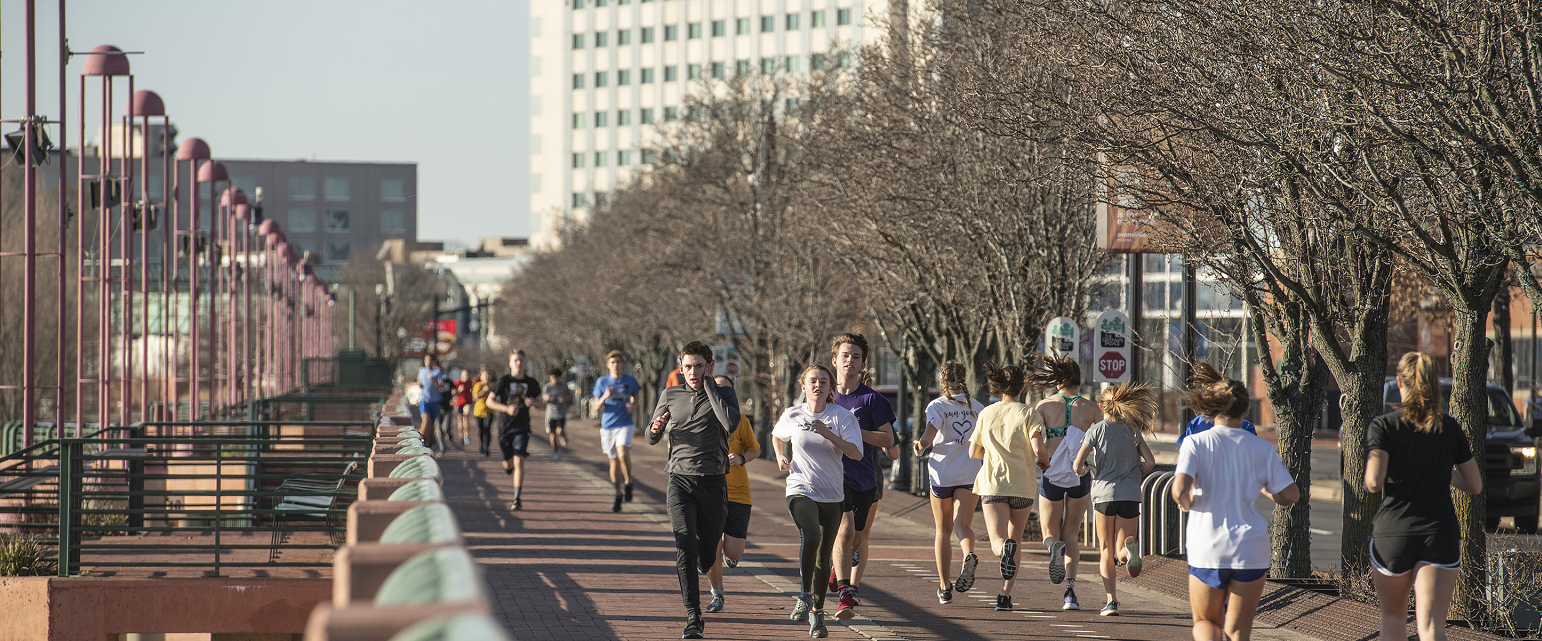 people running along the pigeon creek greenway passage in downtown evansville